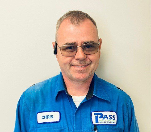 Man in blue work uniform and tinted glasses, smiling. Name tag says