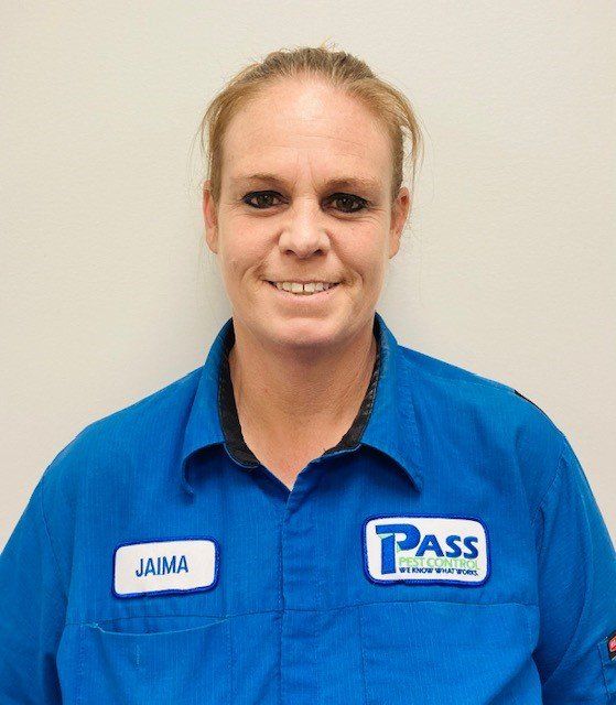 Woman in blue work shirt, smiling, name tag