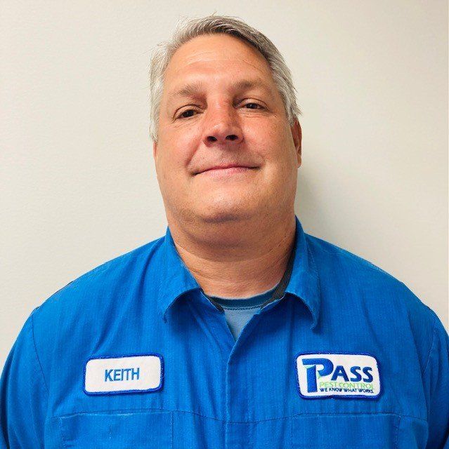 Man wearing blue work shirt smiles, name tag