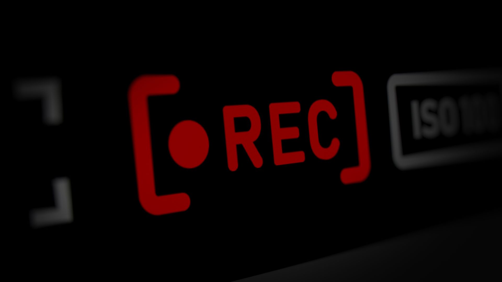 Écran de viseur d'appareil photo numérique affichant un indicateur rouge « REC » et le texte « ISO 100 » sur fond noir.