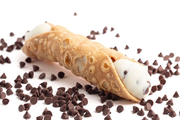 Two sprinkle-topped pastry cones on red tissue paper