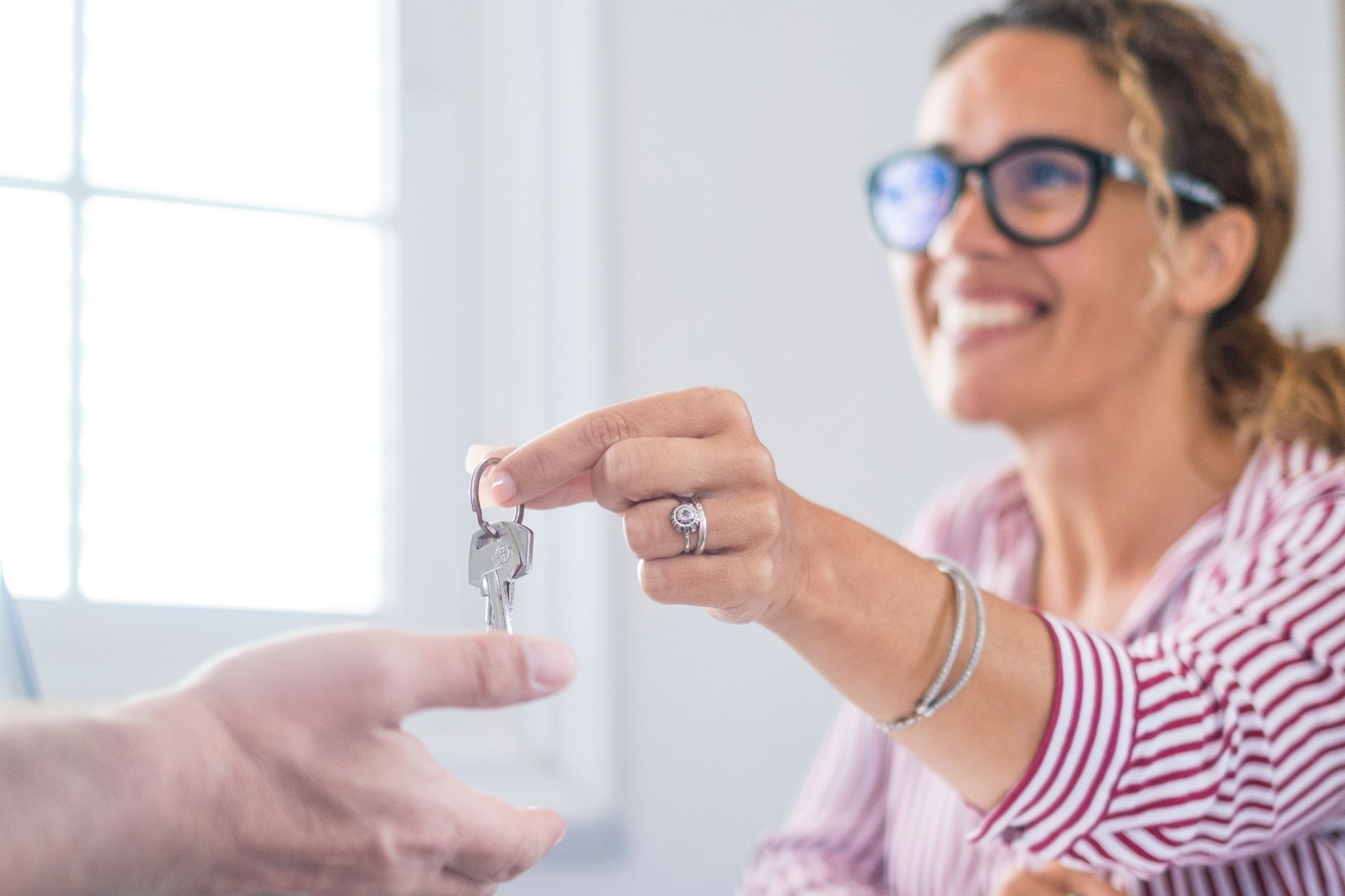A woman is holding a pair of keys in her hand.