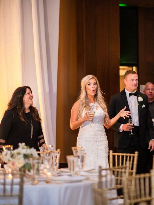 Woman Is Standing Next to a Table Set for a Wedding Reception by Wedding Planner Nashville