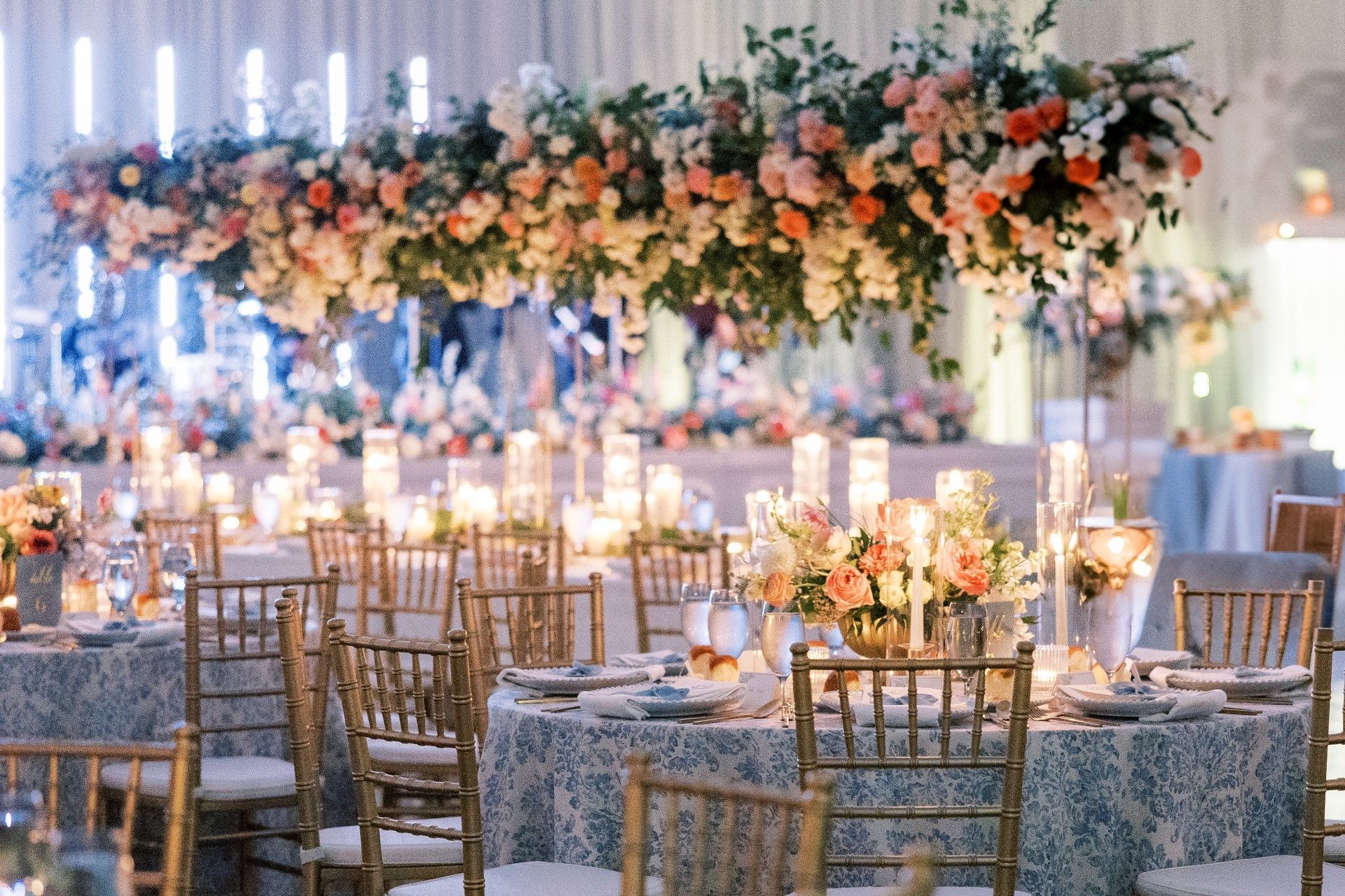 A large room filled with tables and chairs decorated with flowers and candles by Luxury Wedding Planners in Nashville, TN