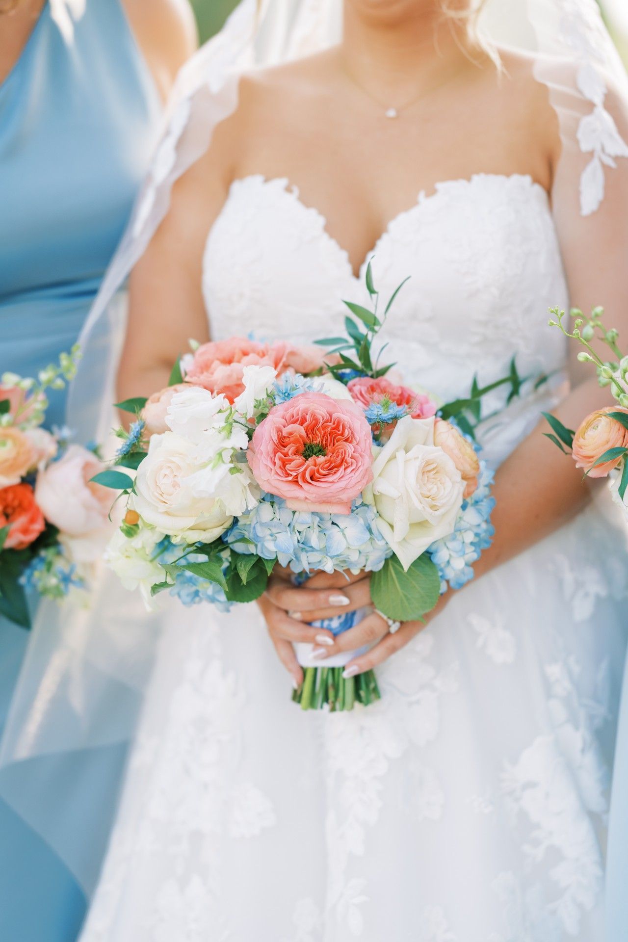 A bride in a white dress is holding a bouquet of flowers by Luxury Wedding Planners in Nashville, TN