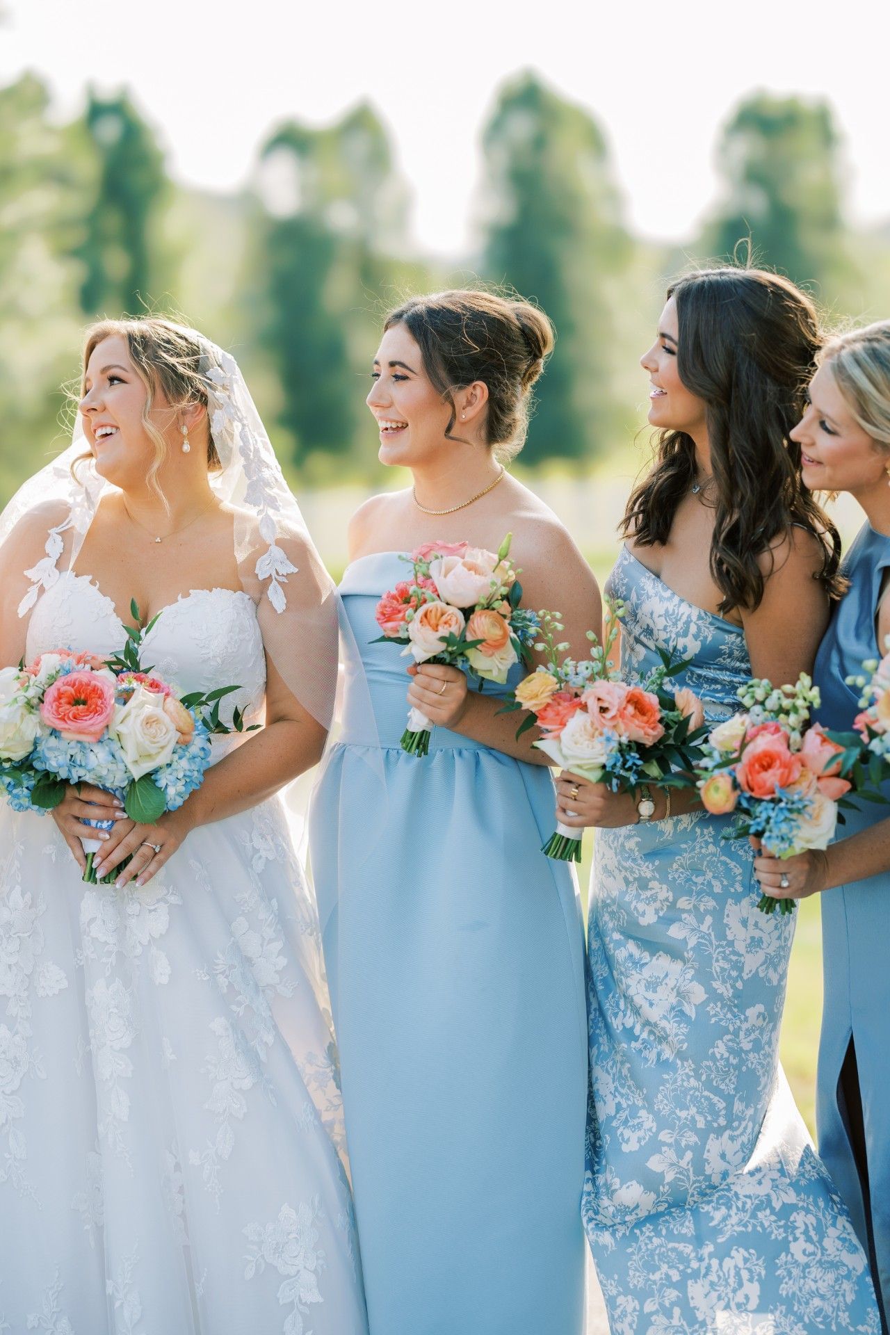 A bride and her bridesmaids are standing next to each other holding bouquets of flowers by Luxury Wedding Planners in Nashville, TN