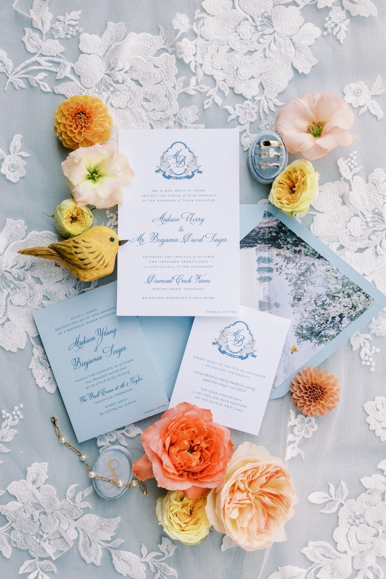 A wedding invitation is sitting on top of a table surrounded by flowers by Luxury Wedding Planners in Nashville, TN