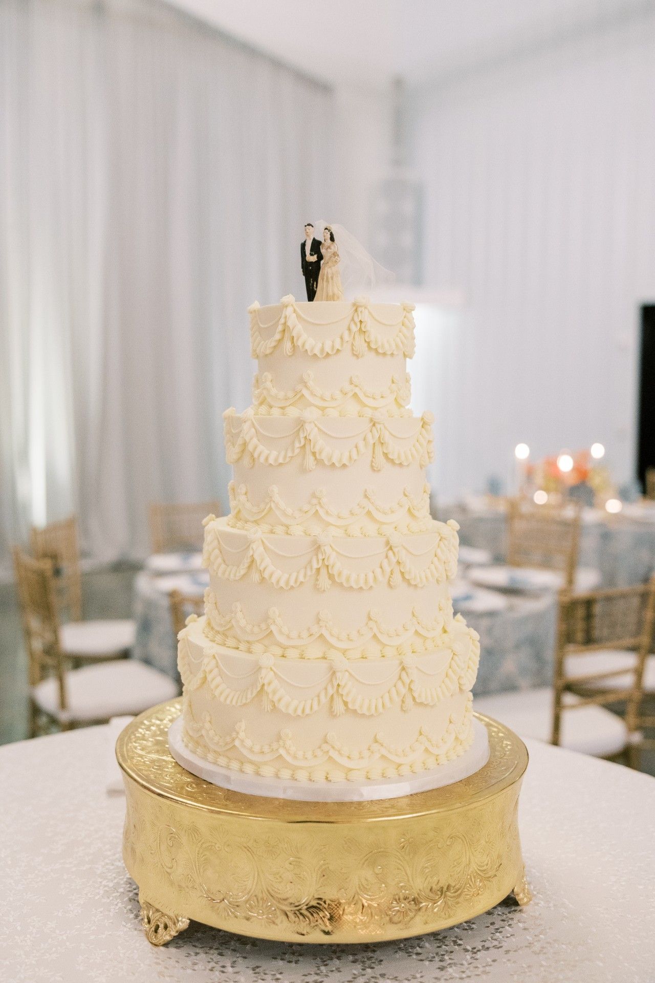 A white wedding cake with a bride and groom figurine on top of it by Luxury Wedding Planners in Nashville, TN