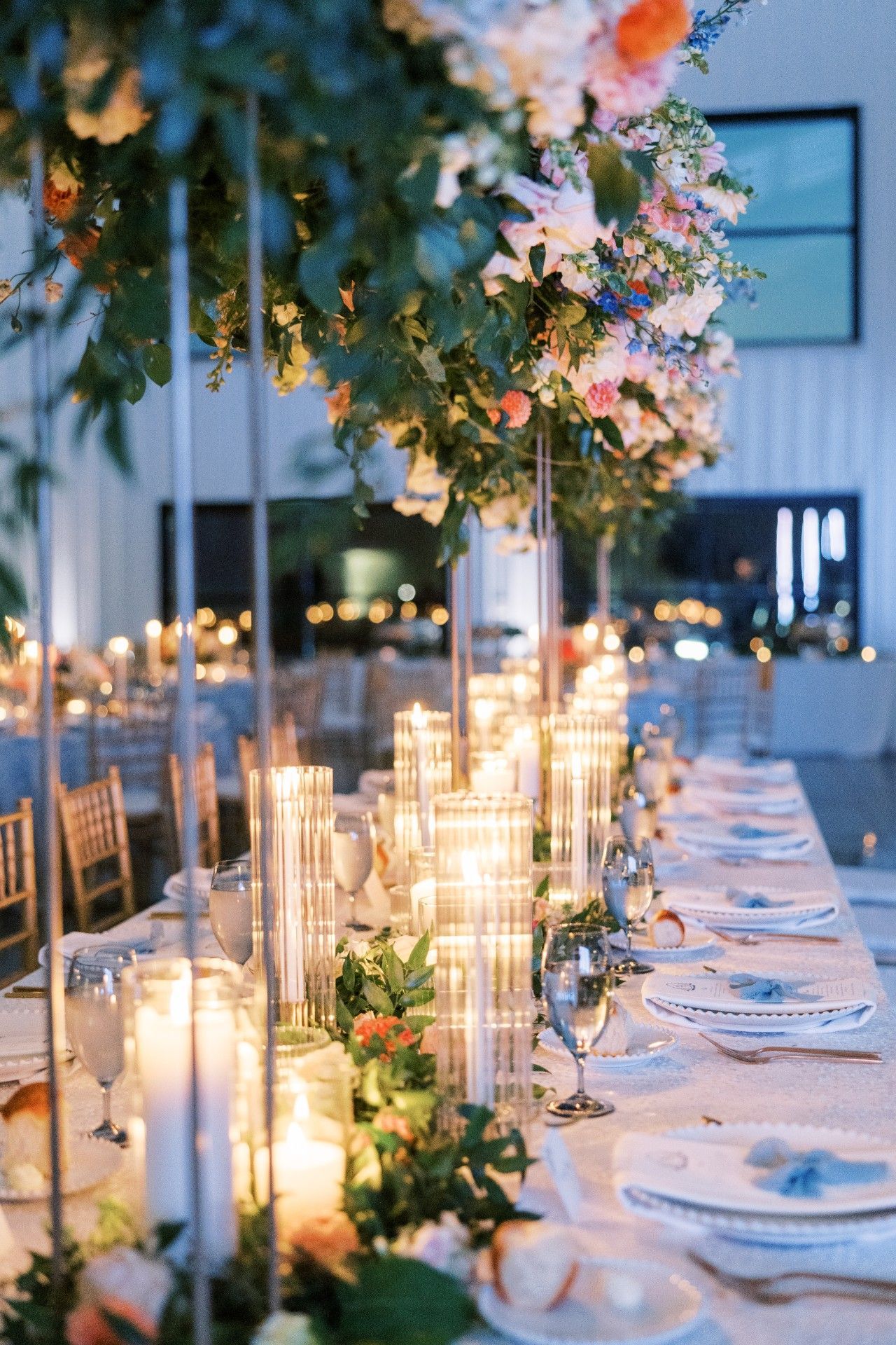 A long table with candles and flowers on it by Luxury Wedding Planners in Nashville, TN