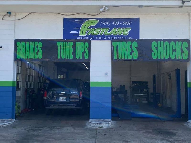 Auto repair shop storefront with signs for brakes, tune ups, tires, and shocks