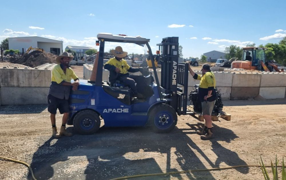 A Group of Men in Pink Safety Vests Are Working in a Yard — Beehive Property Maintenance in Blackwater, QLD