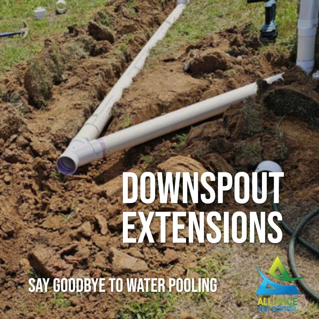 Downspout extensions installation: white PVC pipes in a trench, preventing water pooling.