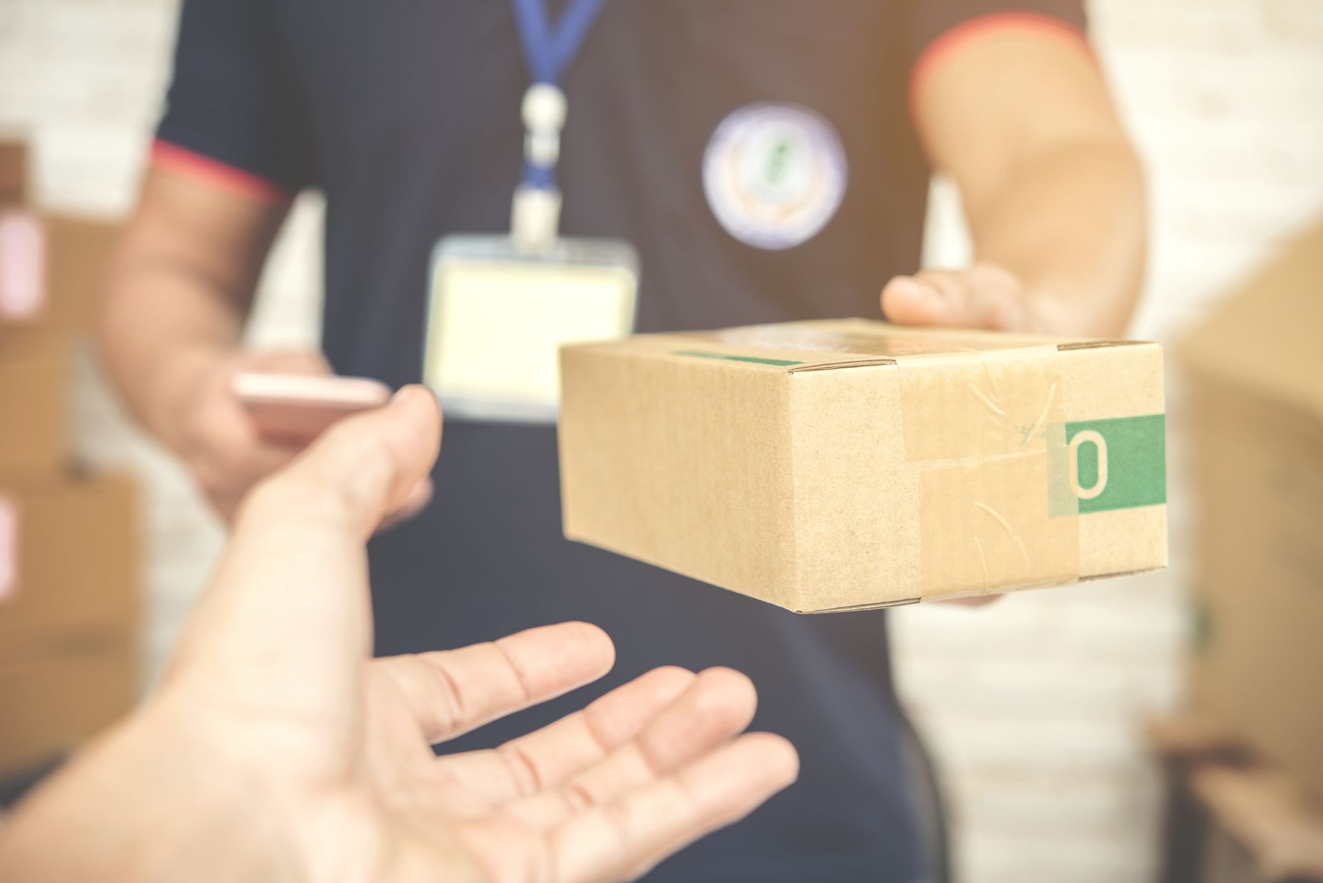 Uma pessoa está entregando uma caixa de papelão a um entregador.