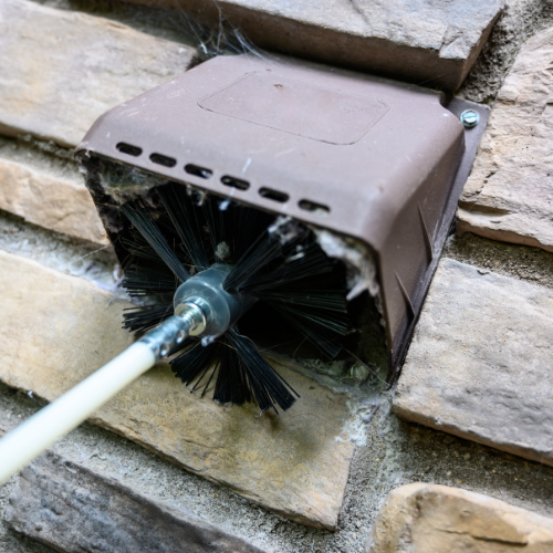 A white vent on the side of a building