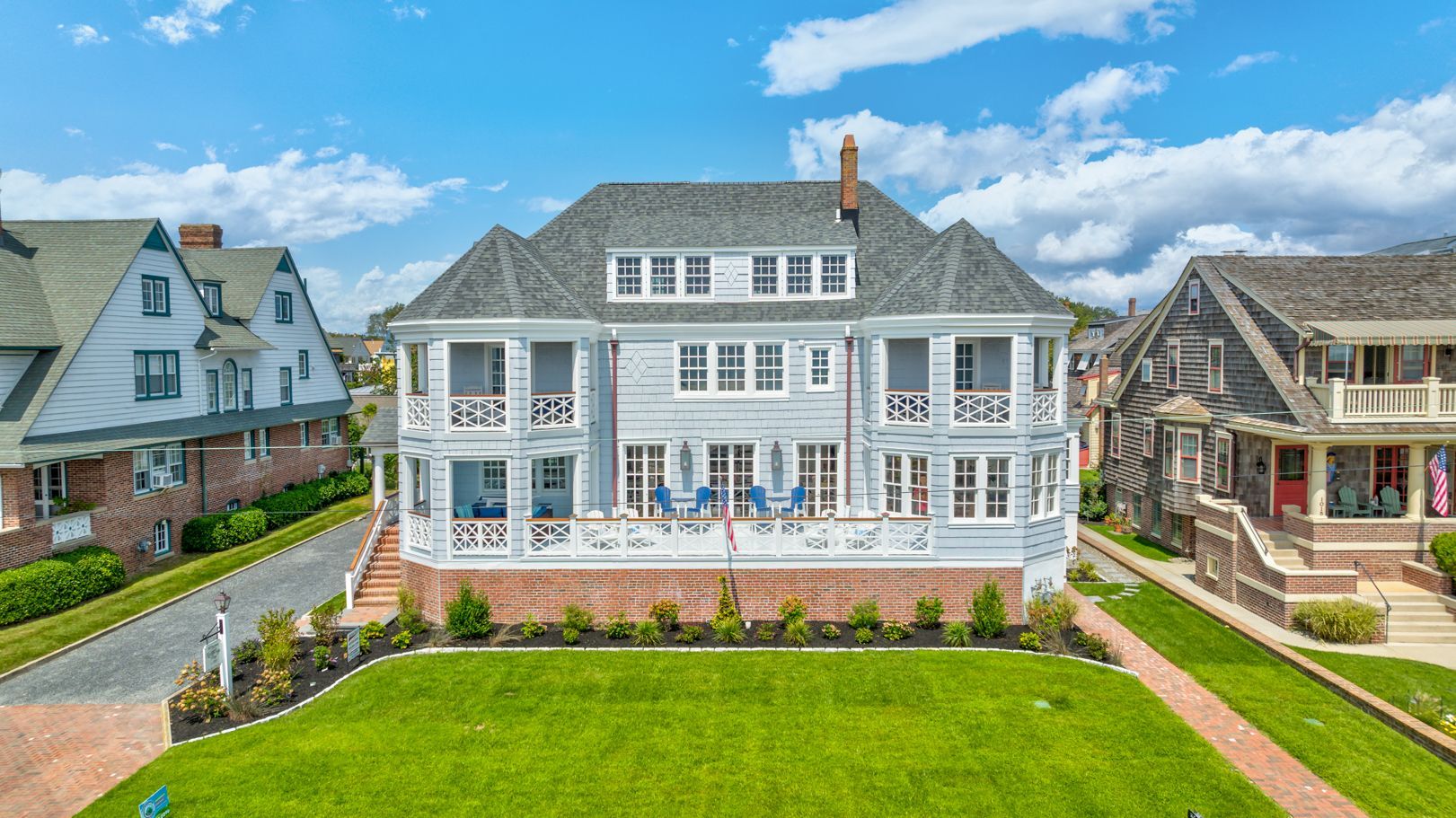 An aerial view of a large white house with a large lawn in front of it.