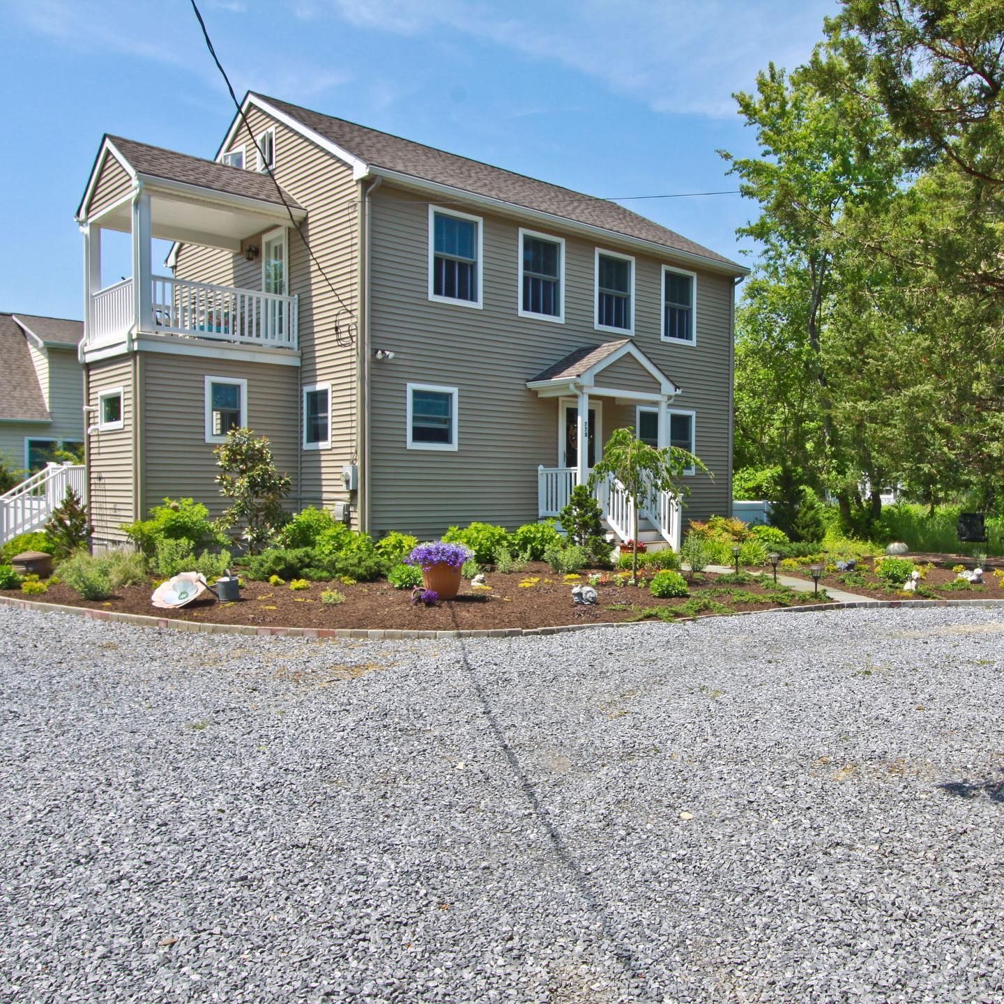 A house with a gravel driveway in front of it