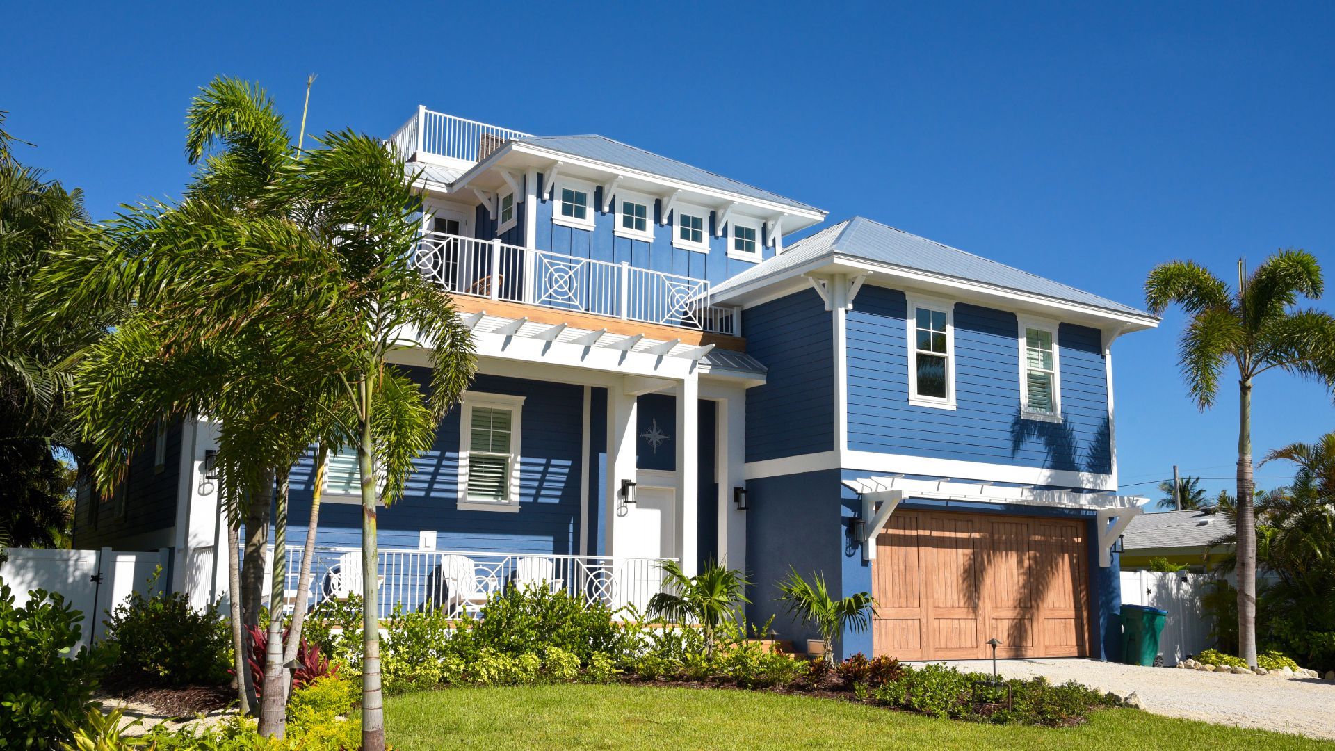 A large blue and white house with a wooden garage door
