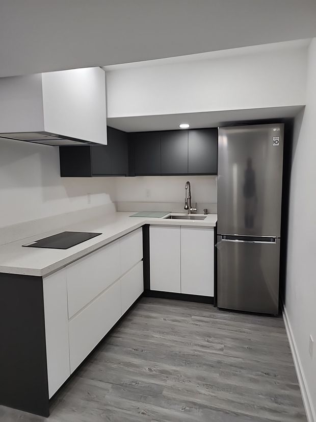 Refinished kitchen cabinets featuring a smooth, modern painted finish.