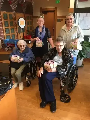 A nurse with two old person outside of the center