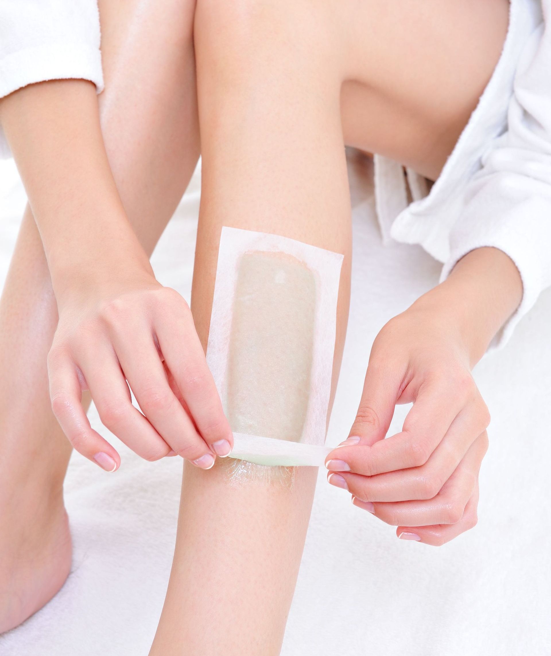 Person removing wax strip from leg.