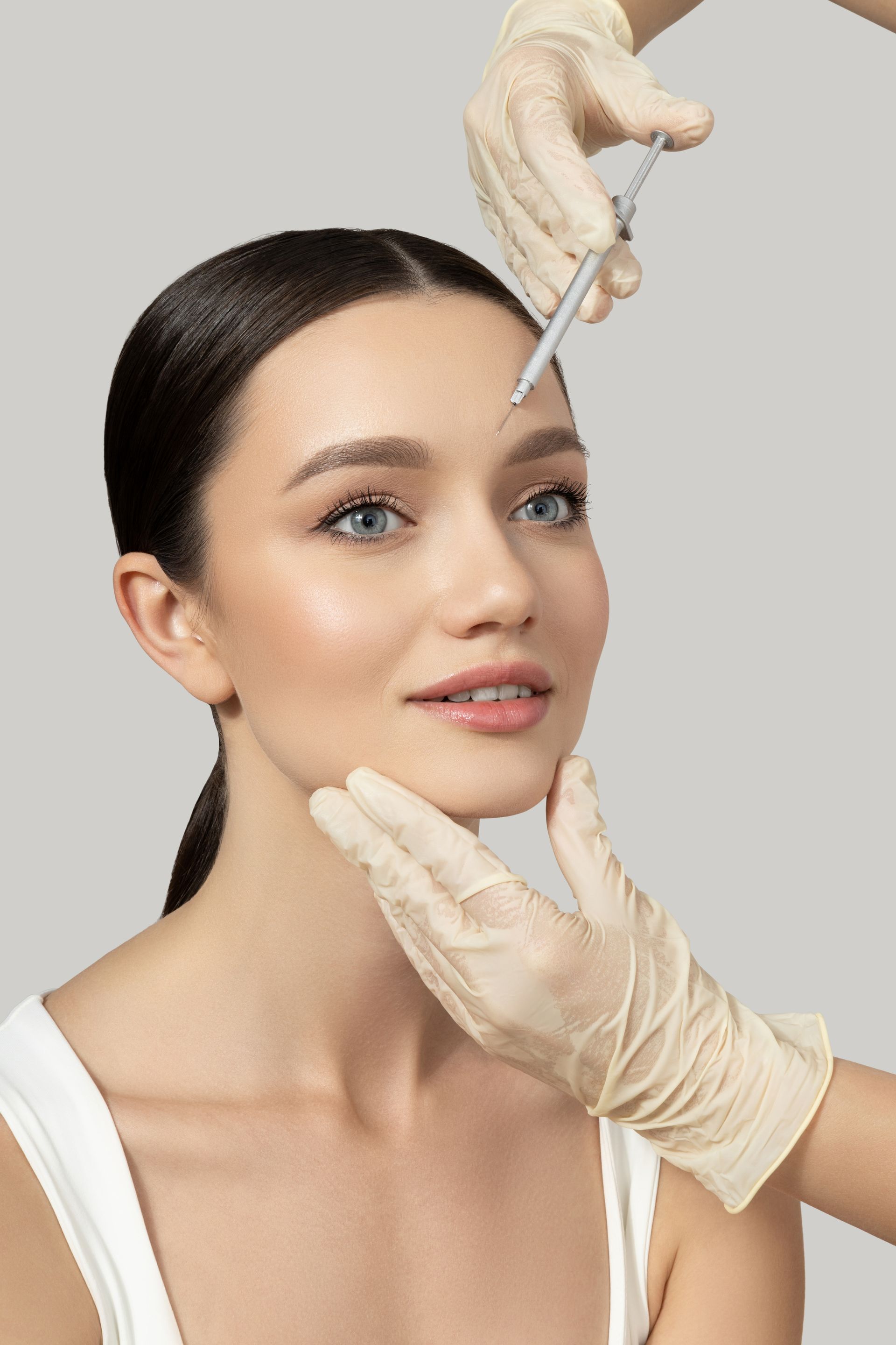 Woman with hands examining her face; scissors held above eyebrow.