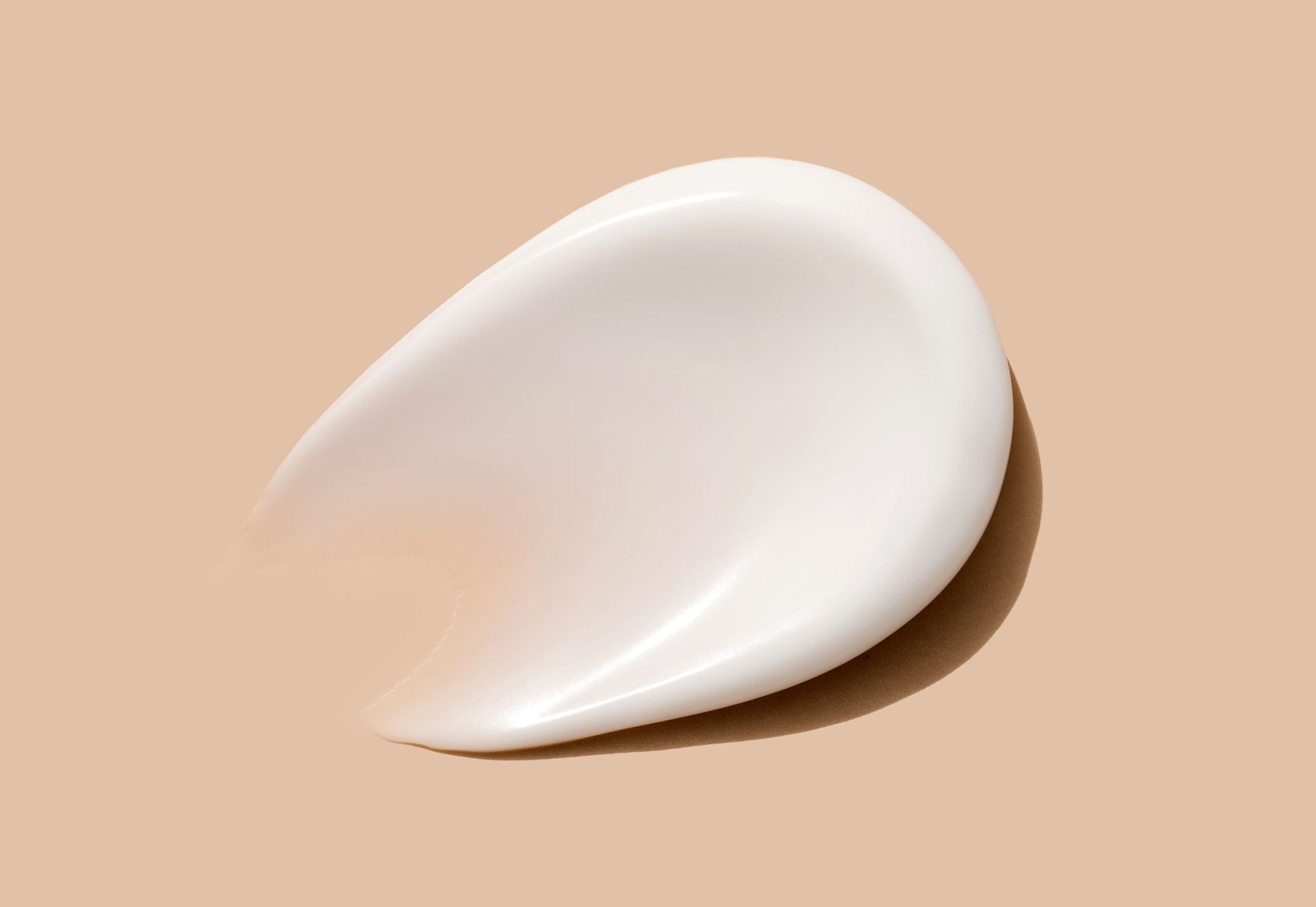 Swirl of white cream on a light brown surface.