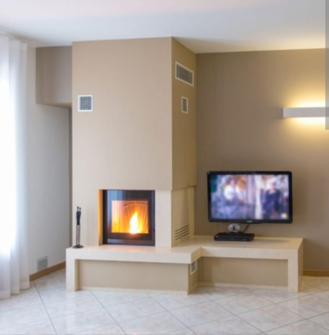 Soggiorno moderno con camino acceso, TV a parete, pareti beige e pavimento piastrellato.