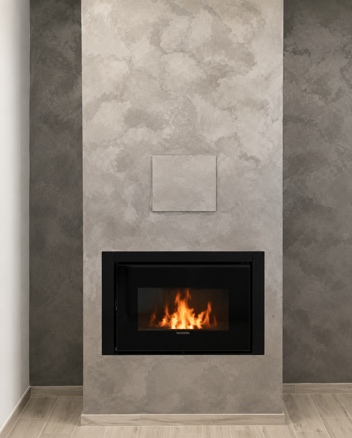 Caminetto moderno per soggiorno con piccolo fuoco incastonato in una cornice a parete grigia.