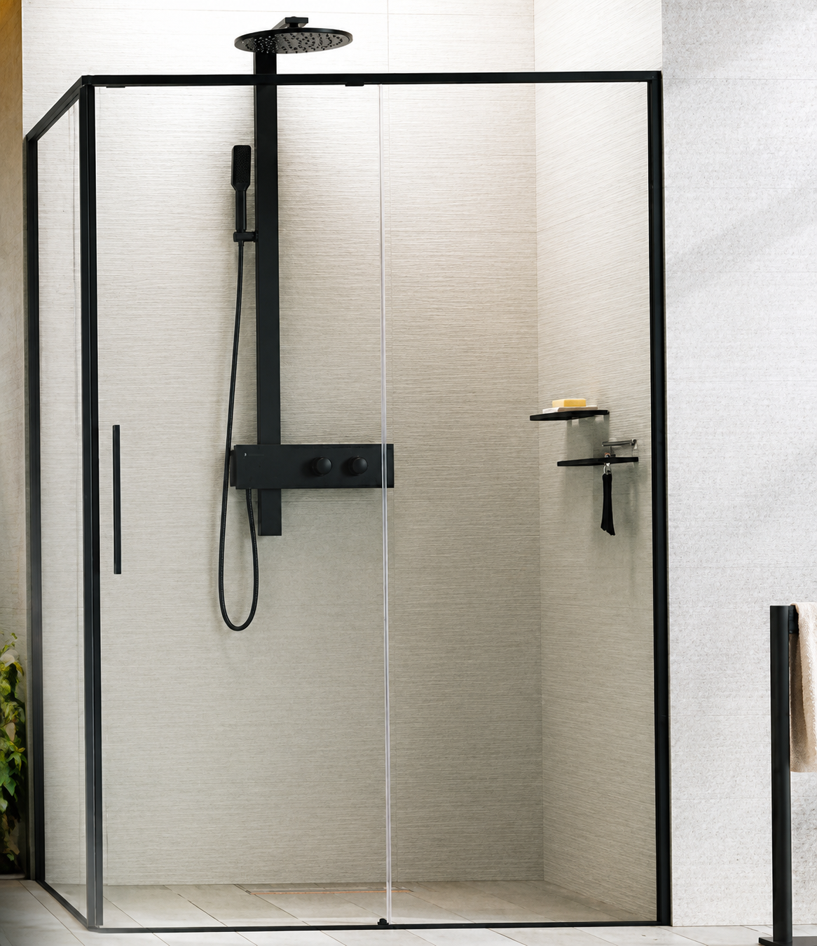 Cabina doccia moderna con struttura nera, vetro trasparente e rubinetteria a parete su piastrelle chiare.
