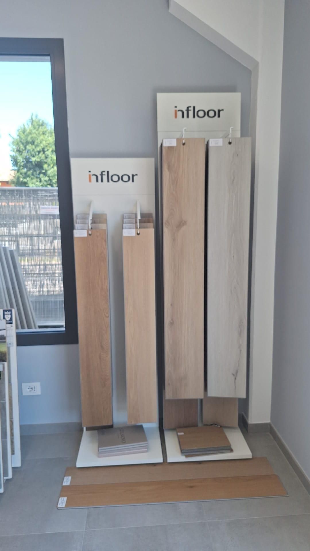 Tre campioni di pavimenti in legno Infloor esposti in un luminoso angolo dello showroom.