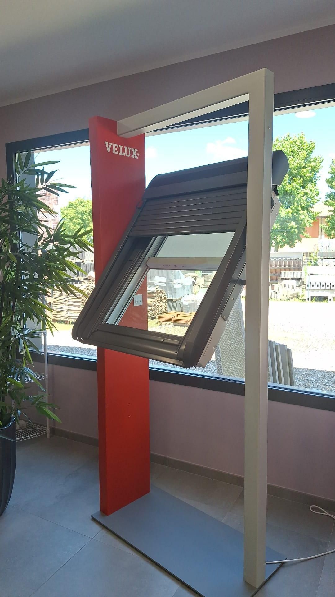 Chiosco touchscreen inclinato con cornice rossa e beige in un luminoso ambiente interno.