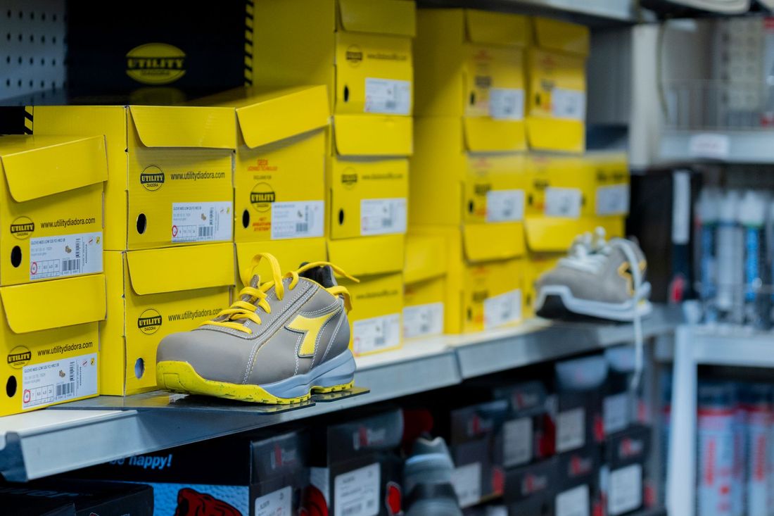 Scaffale di un negozio di scarpe con scatole gialle Nike e una sneaker grigio-gialla esposta davanti