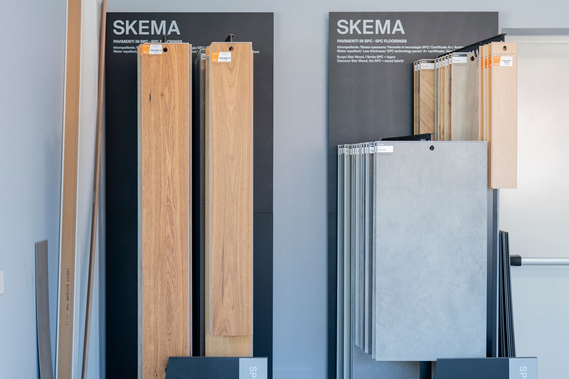 Esposizione SKEMA di tre campioni di pannelli a parete in legno e metallo in uno showroom.