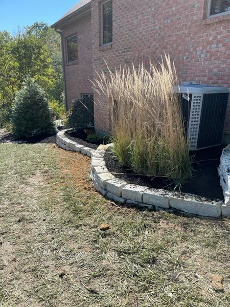 A brick house with a green air conditioner in the backyard.