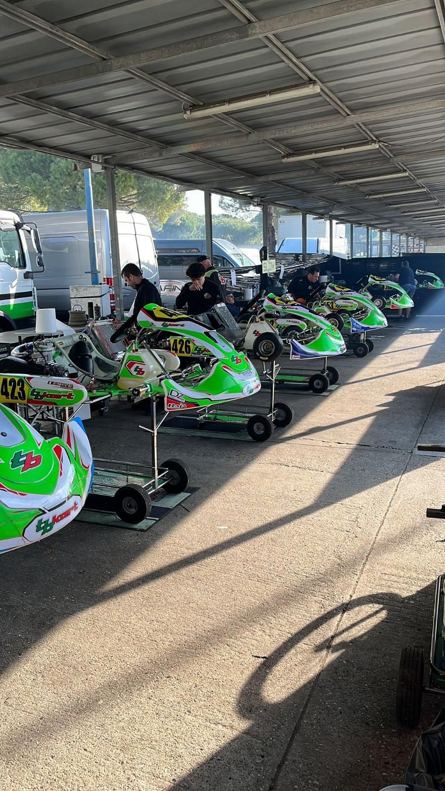 Una fila di go-kart è parcheggiata in un garage sotto un tetto.