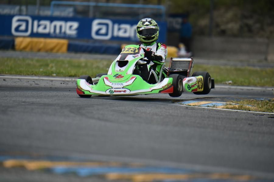 Una persona sta guidando un go-kart verde e bianco su una pista.