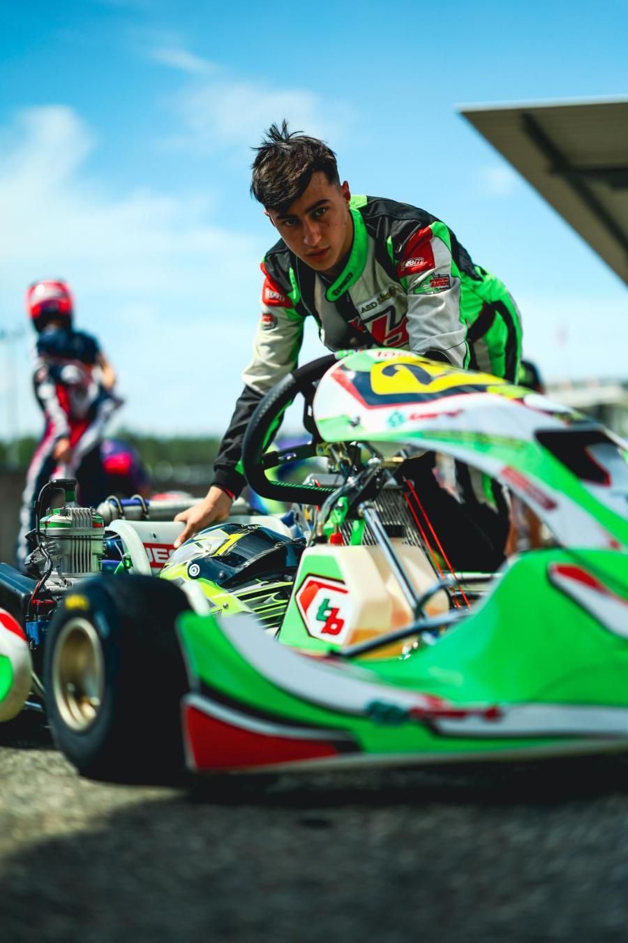 Un uomo sta lavorando su un go-kart verde e bianco