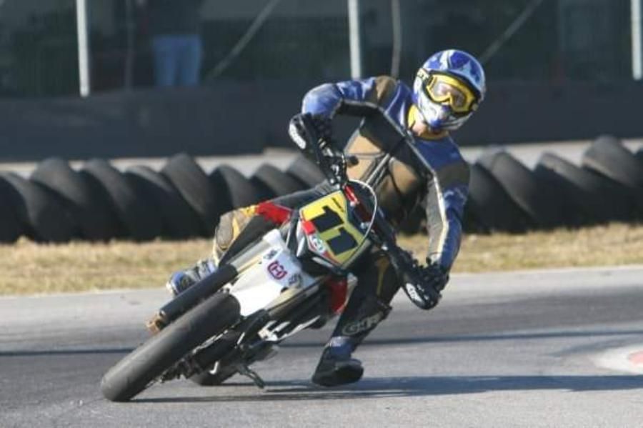 Una persona che guida una motocicletta con il numero 18