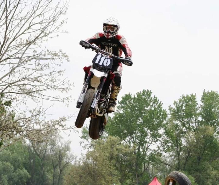 Una persona che guida una moto da cross con il numero 110 sopra