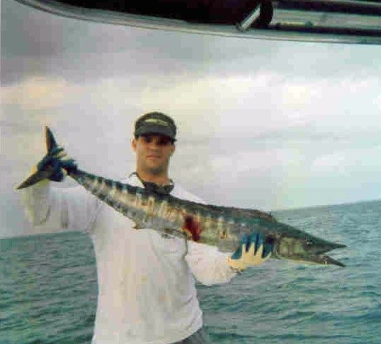 a man is holding a large fish in his hands