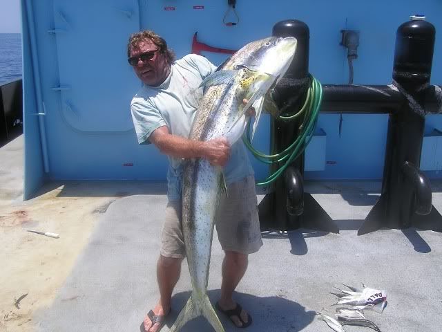 A man is holding a large fish on a boat