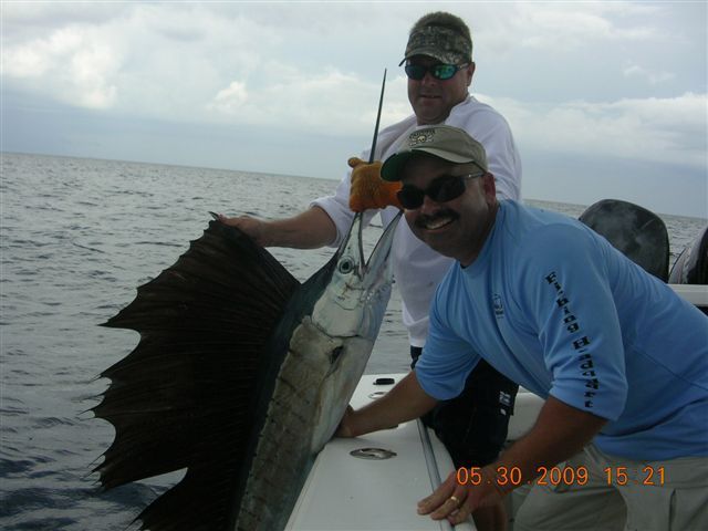Two men on a boat holding a sailfish with the date 05 30 2009