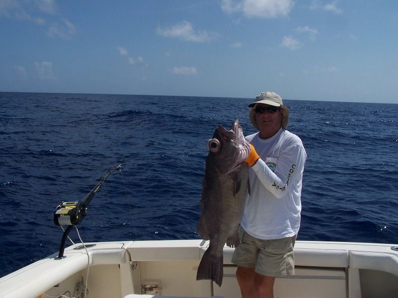 A man on a boat holding a large fish