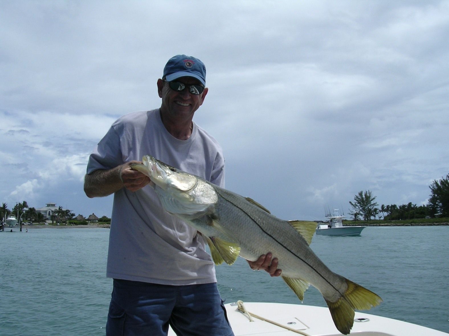 A man on a boat holding a large fish