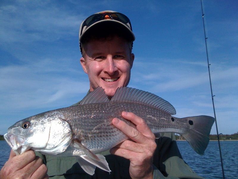 A man is holding a large fish in his hands