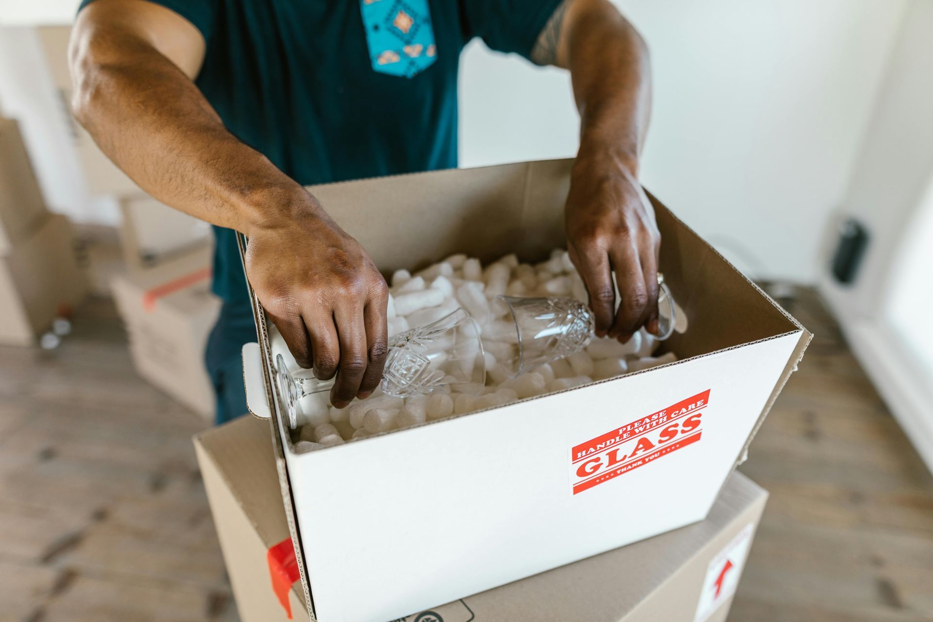 Person packing a box with packing peanuts, marked