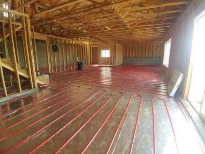 Unfinished attic with exposed wood framing and red radiant floor tubing installed on the subfloor Unfinished attic with exposed wood framing and red radiant floor tubing installed on the subfloor