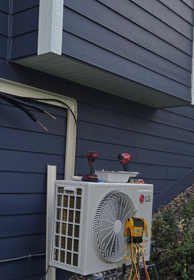 House exterior with a gray utility meter and white piping beside blue siding