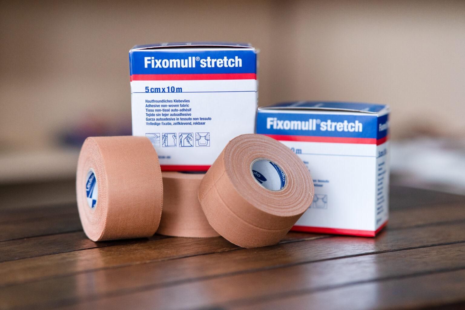 Three Rolls Of Fixomull Stretch Tape Are Sitting On A Wooden Table — Port Macquarie Physio & Pilates In Port Macquarie, NSW