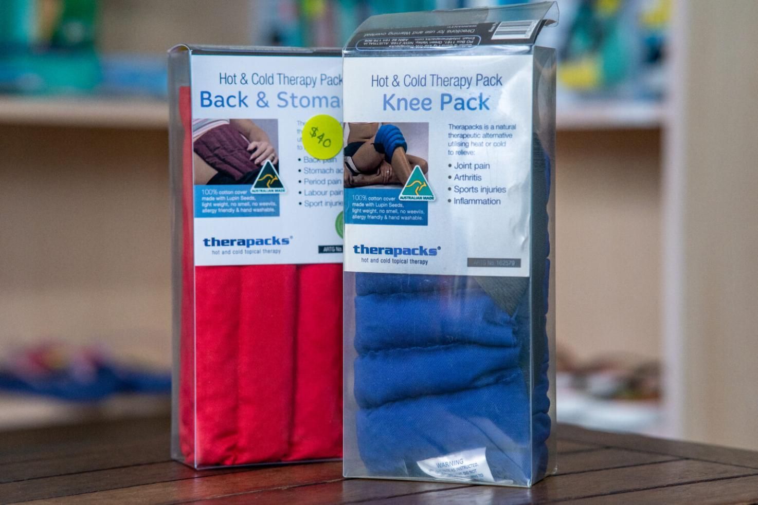 Two Boxes Of Knee Packs Are Sitting On A Wooden Table — Port Macquarie Physio & Pilates In Port Macquarie, NSW